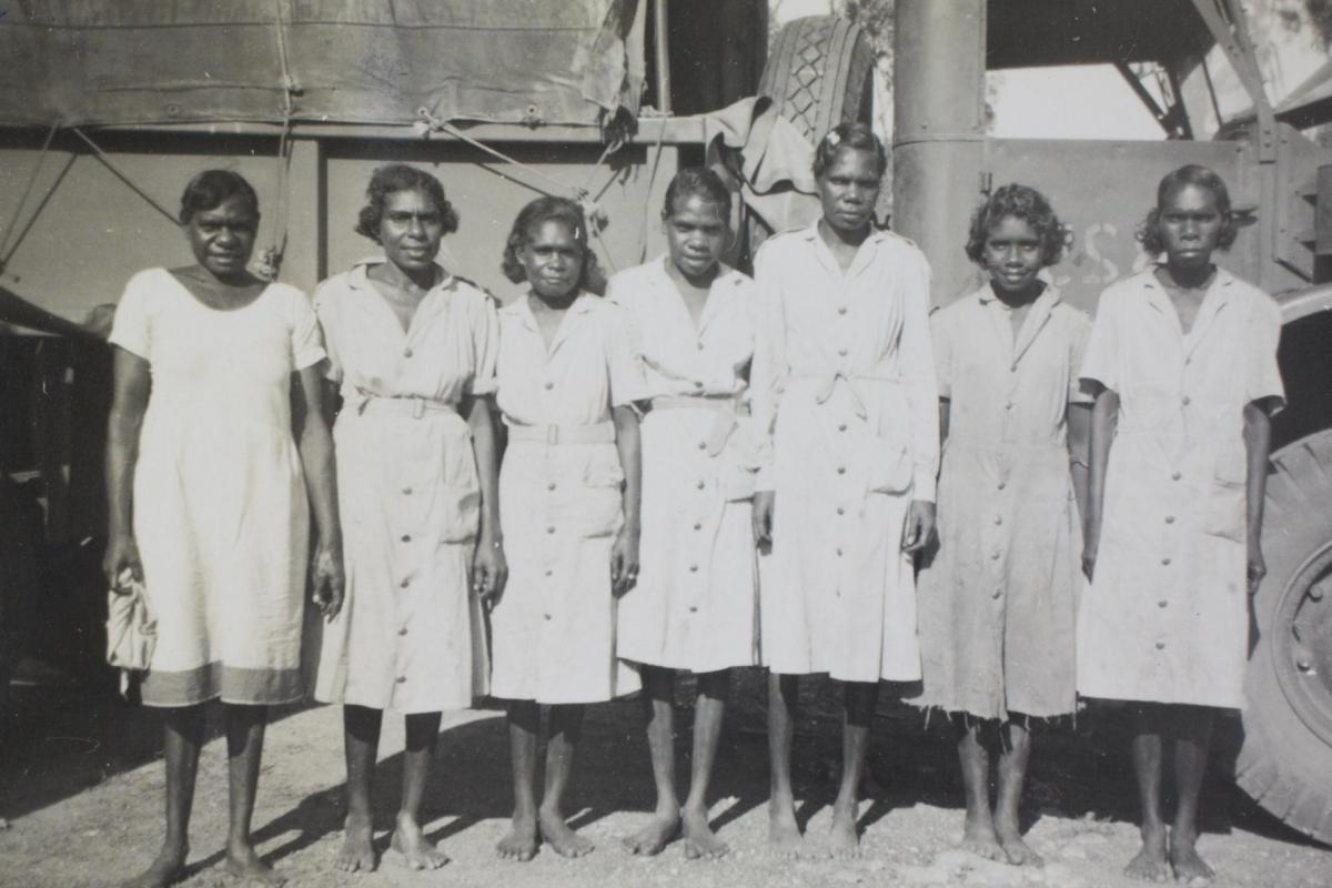 Seven aboriginal women in uniform standing shoulder to shoulder, posing in front of military truck