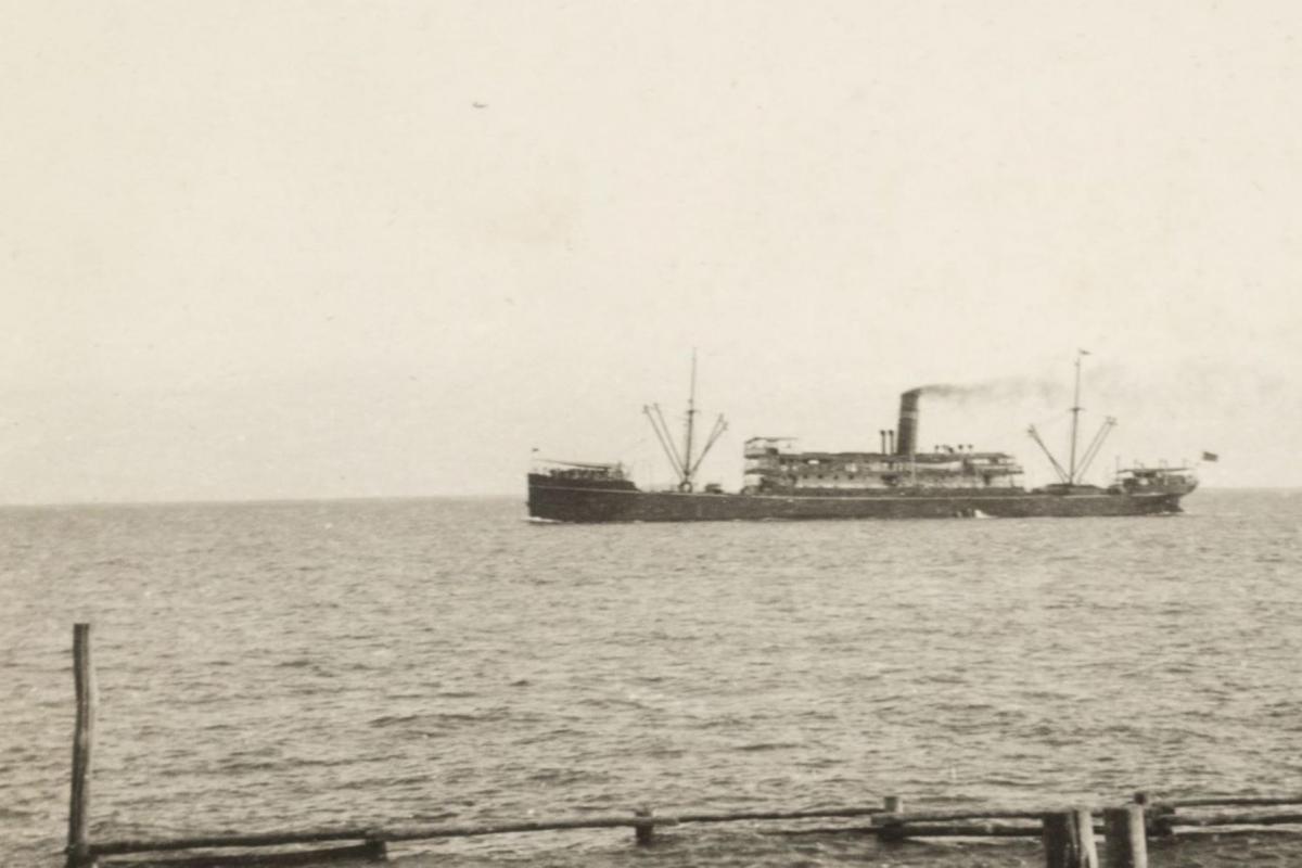 Photograph of SS Mataram at sea with small post and rail sea baths in the foreground. 
