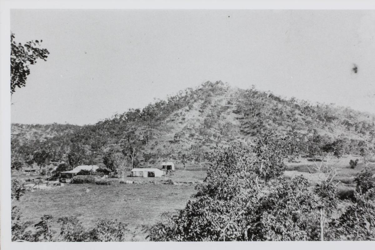 A picture of the remote Mount Bonnie Homestead at the base of a hill, surrounded by bush. 