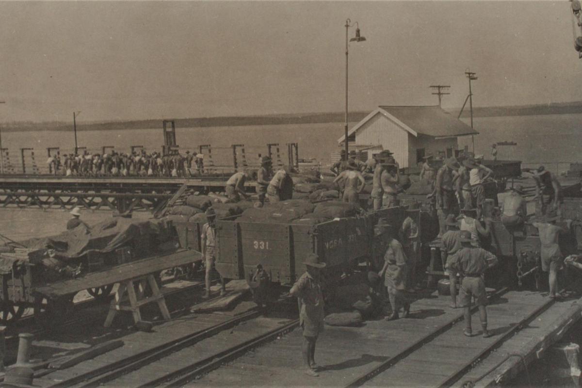 Photograph of soldiers loading trucks at the wharf.