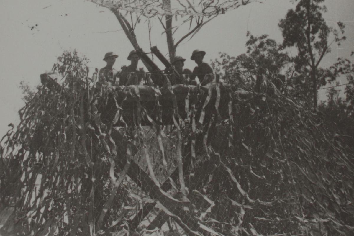 Soldiers on duty in a camouflaged location at a high vantage point.