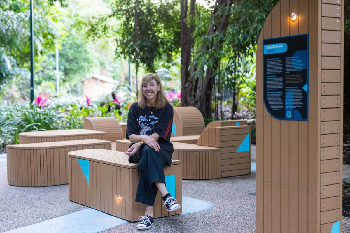 Photograph of artist Gloria Richards sitting among her sculptural seating in the revitalised Damoe-ra Park.