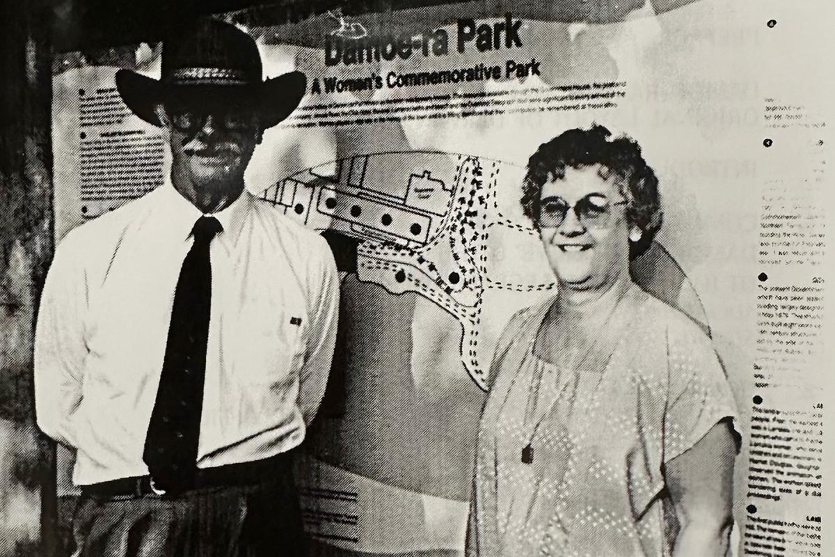Administrator Austin Asche standing beside author Helen J Wilson in front of Damoe-ra Park signage.