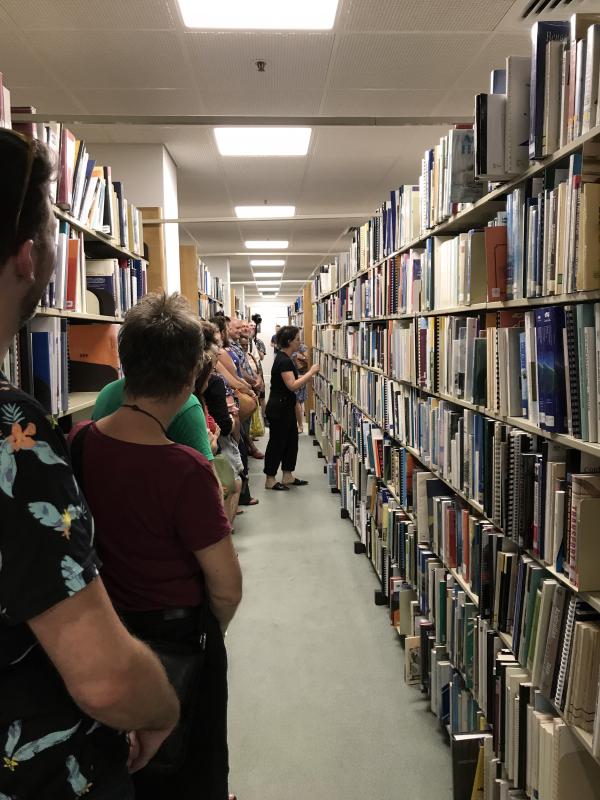 Group of people standing in front of book stacks