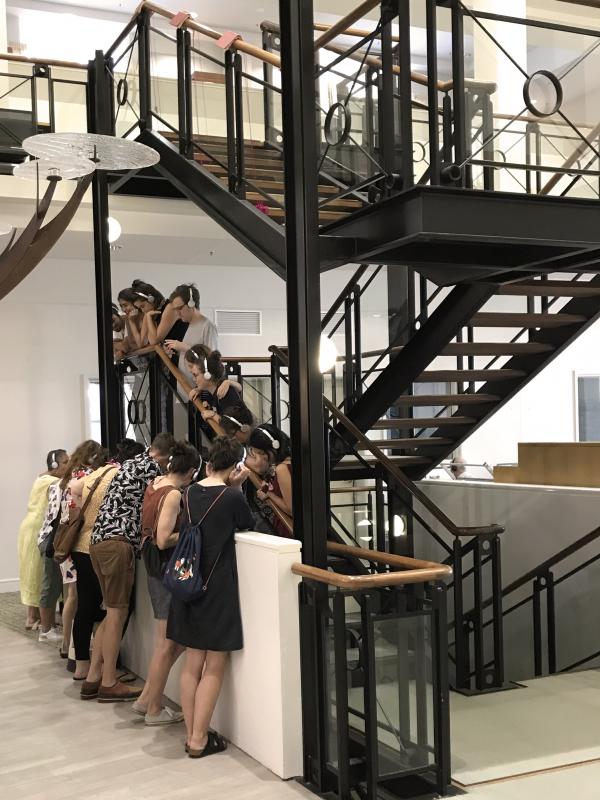 Group of people peering over stairwell
