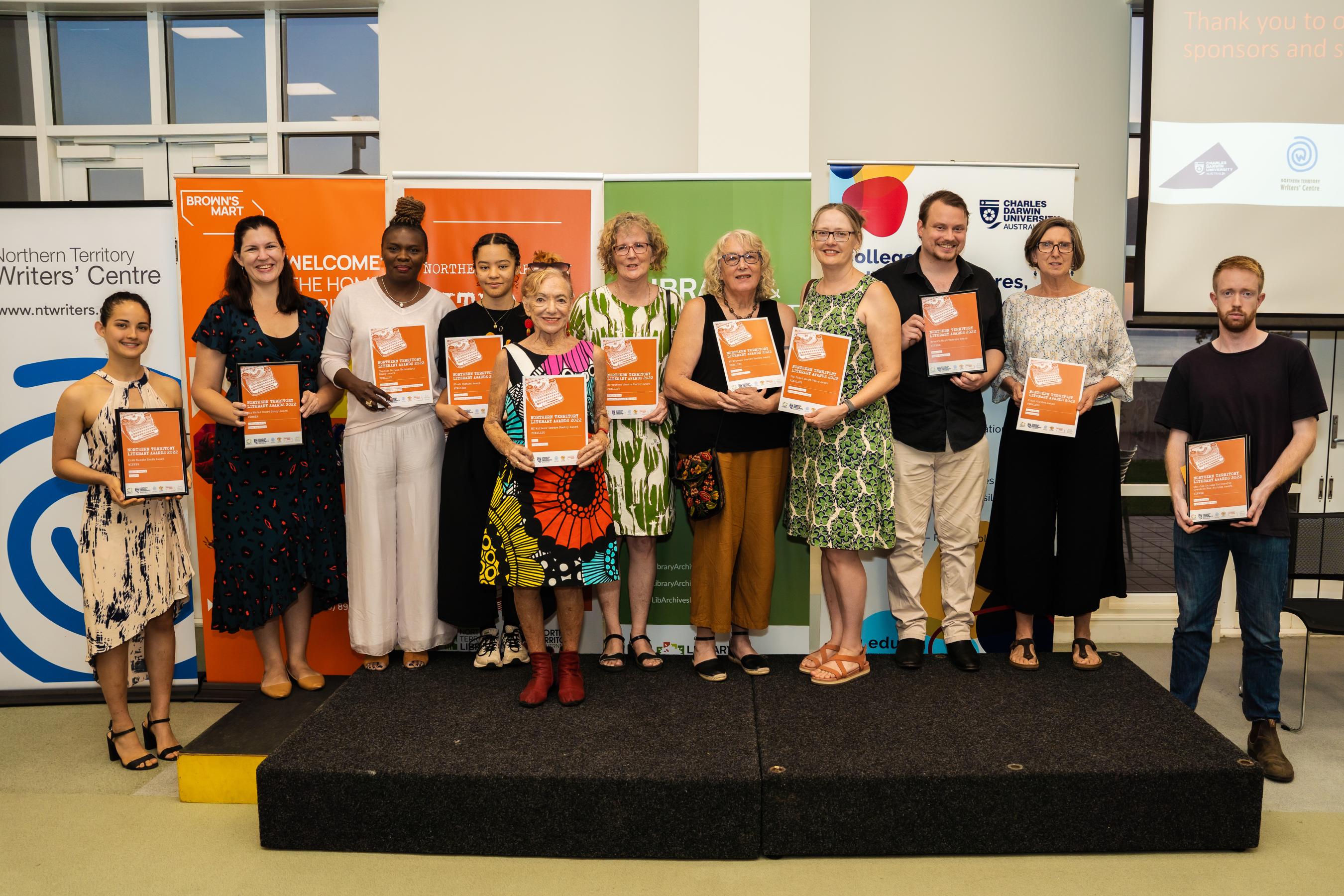 Group pictures of winners and finalists on stage with their certificates