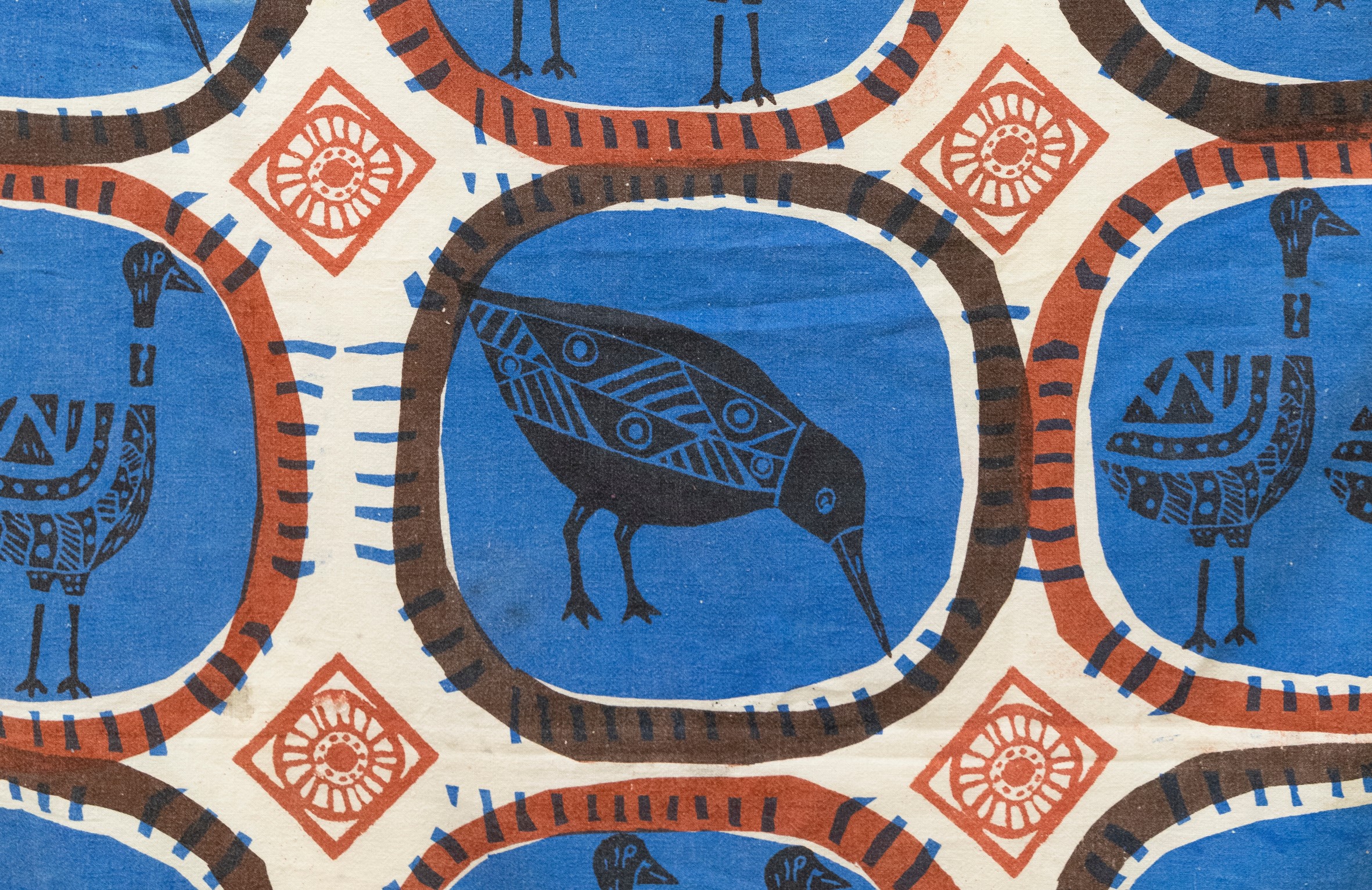 Blue and orange screen printed fabric featuring bird motifs.