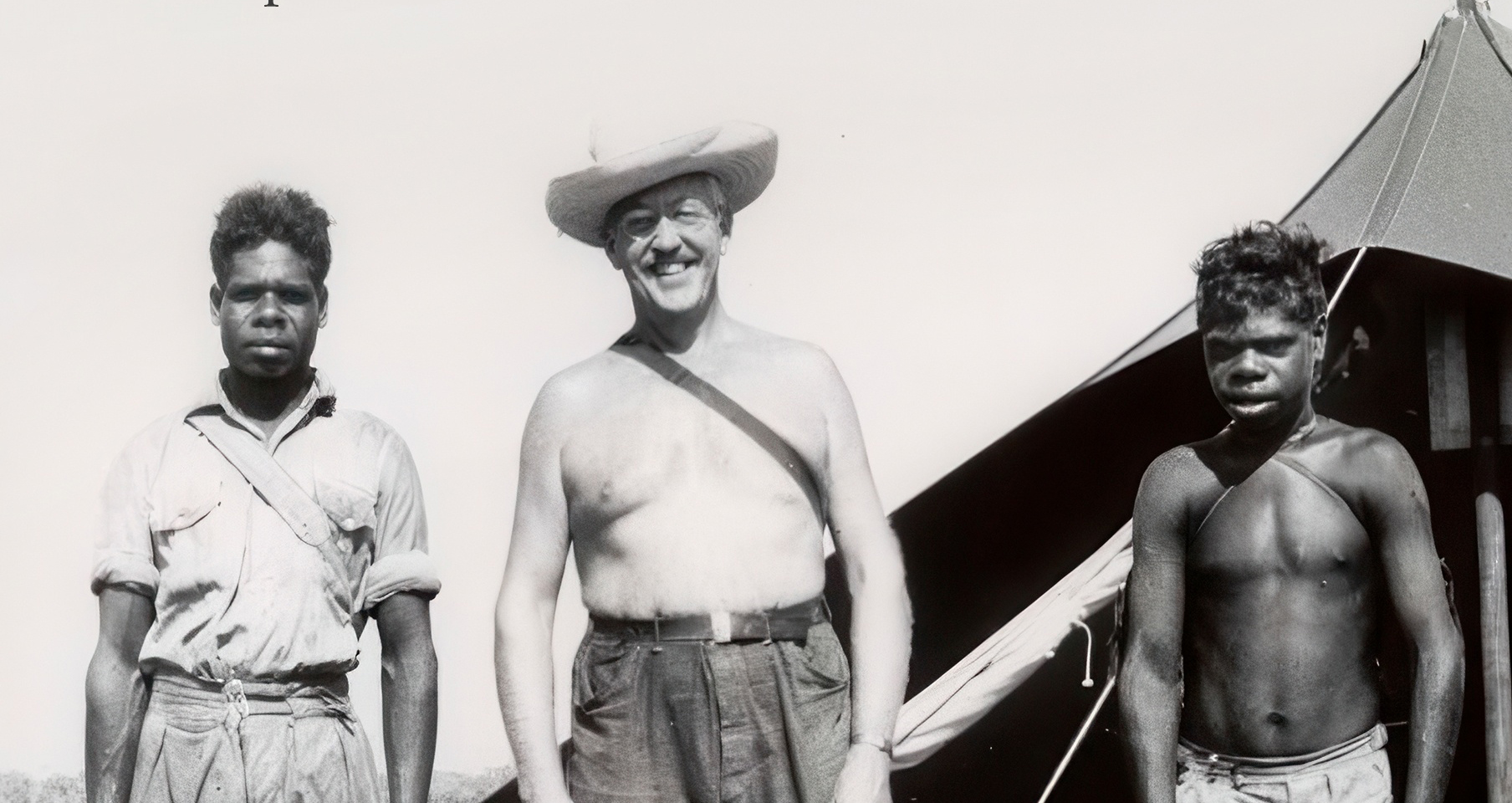 Black and white photograph or three men standing together.