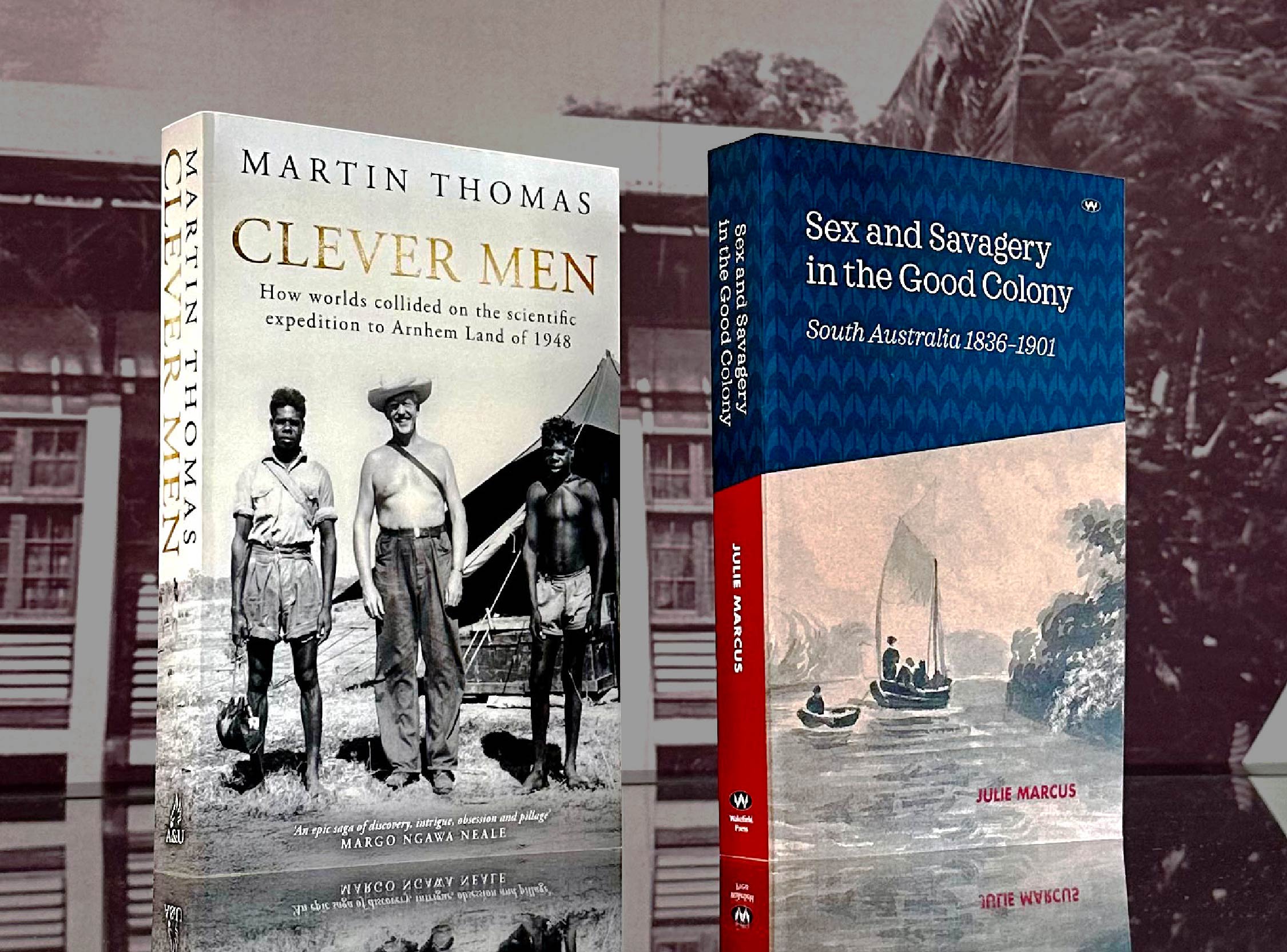 Two books standing up on a glass surface 