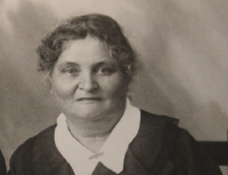 Portrait black and white photograph of Annie Lock wearing black jacket and white collared shirt underneath.