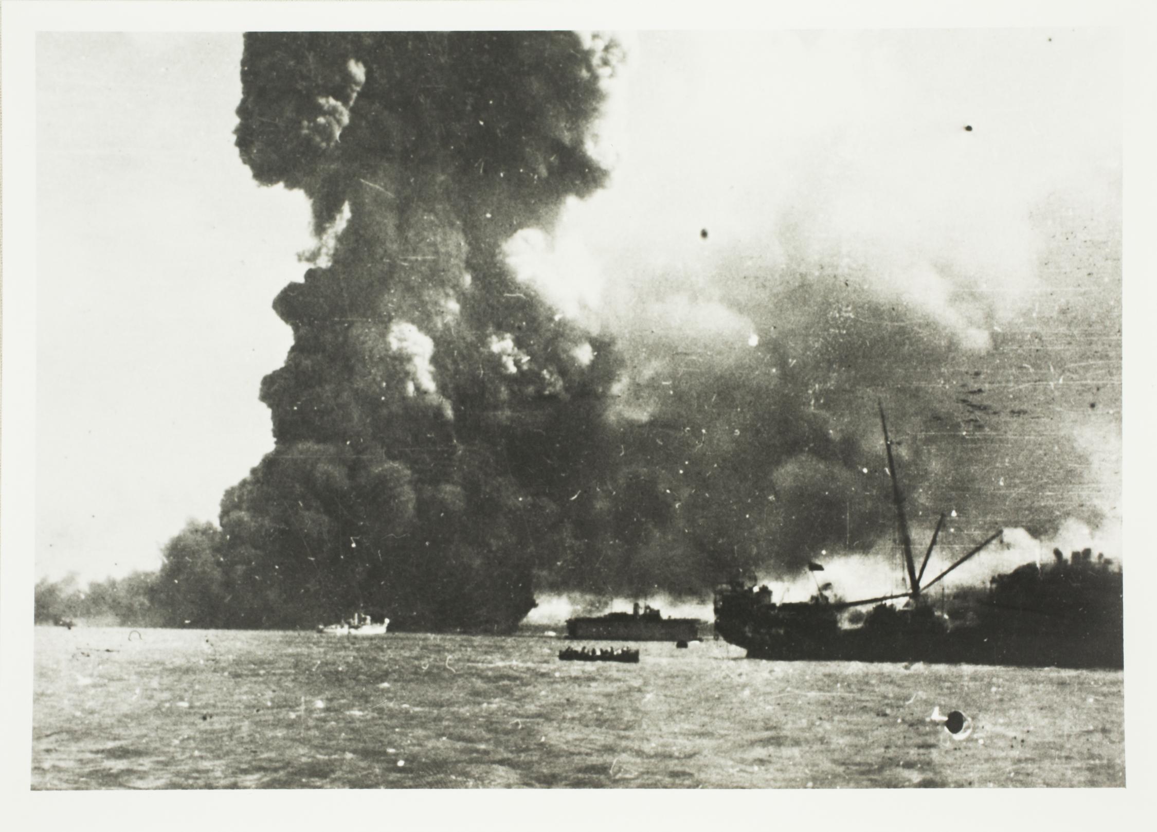 Black smoke rising from bombed ships in Darwin Harbour. 