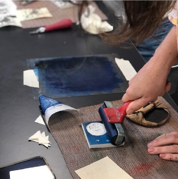 Image of person working with a printblock to create prints