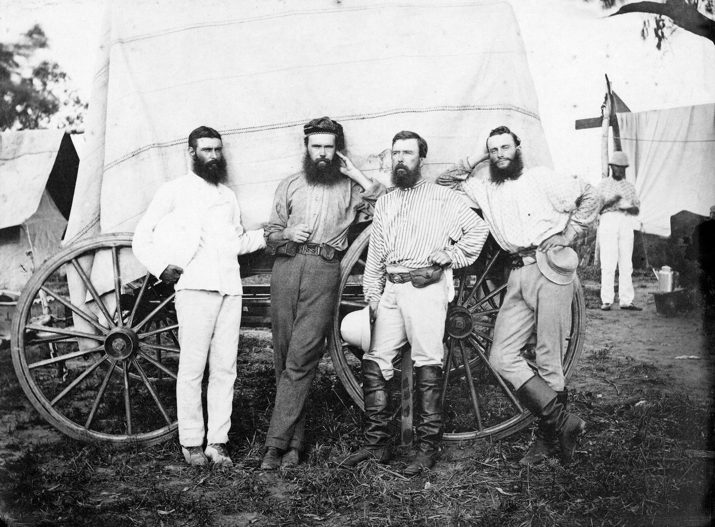 B&W image of four people standing in front of cart