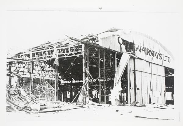 Bombed Guinea Airways hangar on civil strip at the Darwin Aerodrome after the first day of bombing.