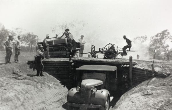 Military transport vehicle loading gravel by use of a "chinaman" for construction of the Stuart Highway.