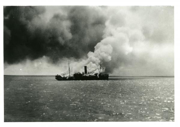 HMAT Zealandia burning on Darwin Harbour during the first raid
