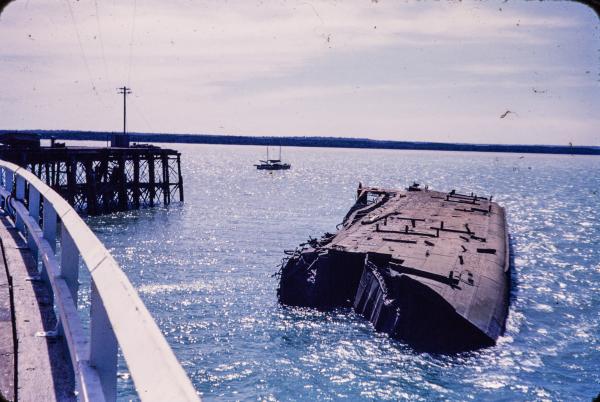 The MV Neptuna lies on its side near Stokes Hill Wharf in Darwin.