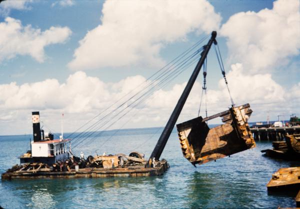 A floating barge crane raises salvage material from Darwin Harbour.