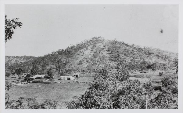 A picture of the remote Mount Bonnie Homestead at the base of a hill, surrounded by bush. 