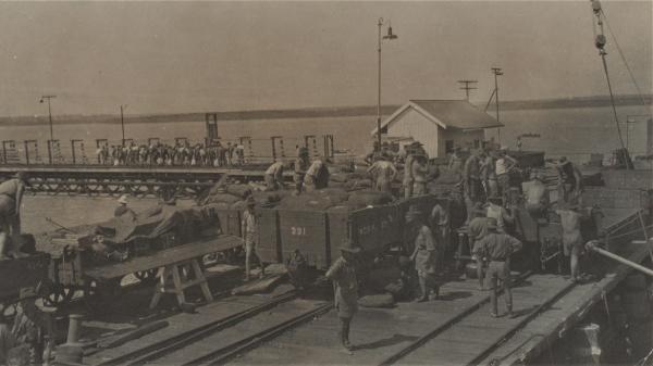 Photograph of soldiers loading trucks at the wharf.