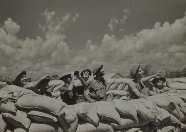 Photograph of soldiers looking at the sky during an air raid.