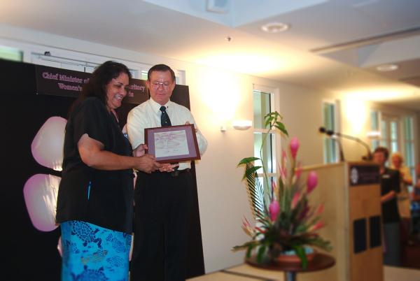 Former Chief Minister, Denis Burke, presents Lenore Dembsky with a certificate in a frame for the Chief Minister's Women's Achievement Awards.