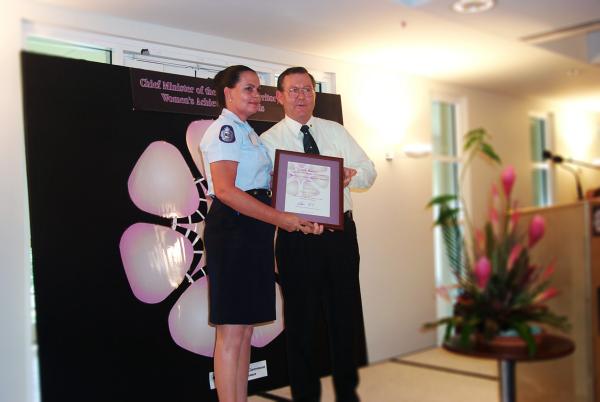 Former Chief Minister, Denis Burke, presents Mary Walshe with a certificate in a frame for the Chief Minister's Women's Achievement Awards.