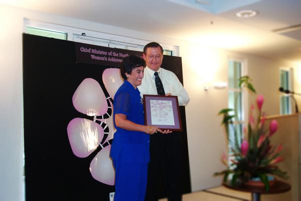 Former Chief Minister, Denis Burke, presents Michelle Hanton with a certificate in a frame for the Chief Minister's Women's Achievement Awards.