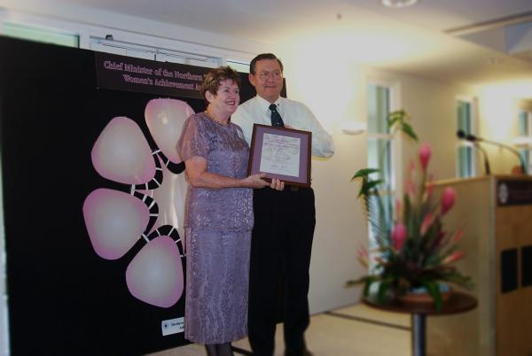 Former Chief Minister, Denis Burke, presents Wendy Leach with a certificate in a frame for the Chief Minister's Women's Achievement Awards.