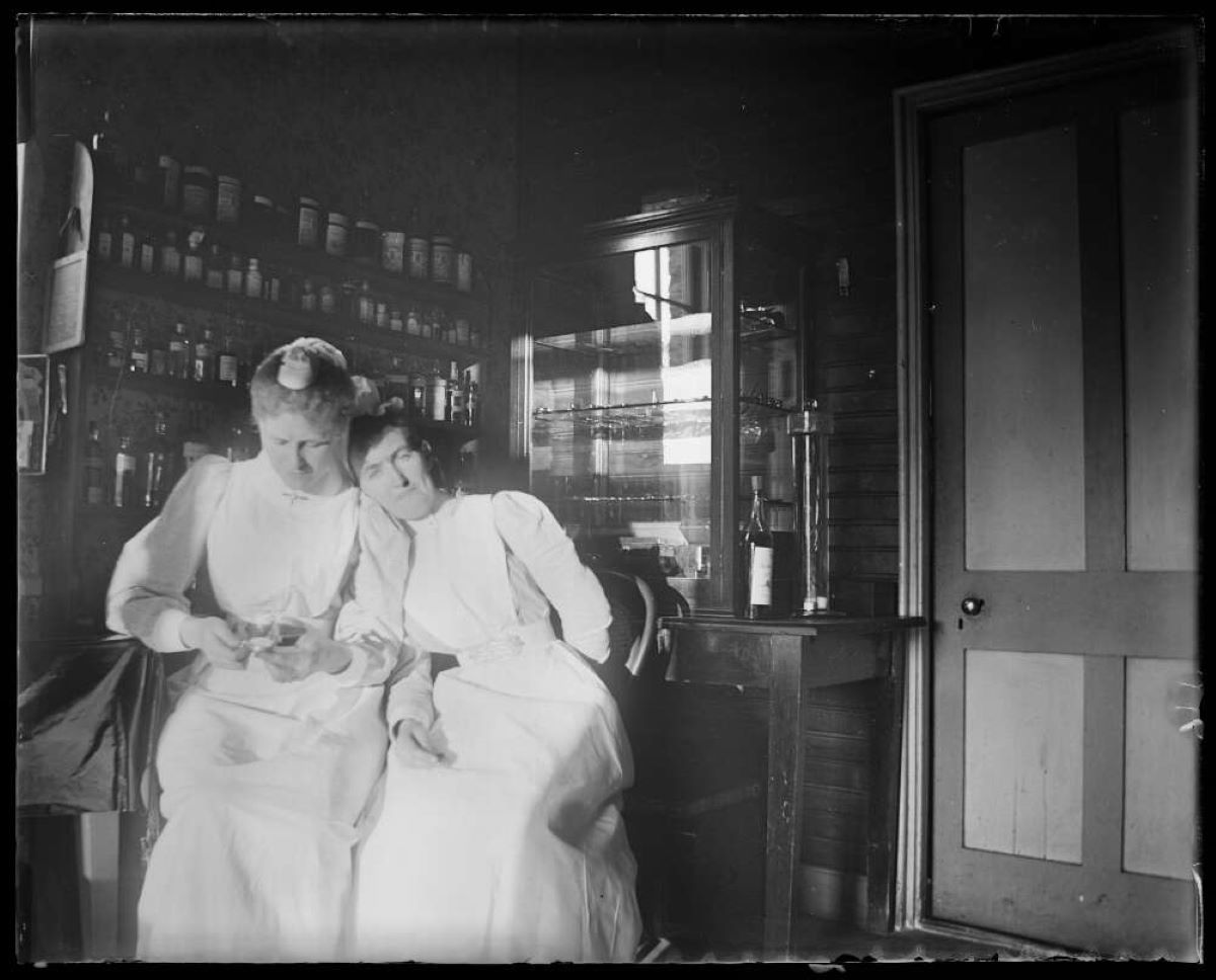 Two sisters are seated at rest in an examination room.